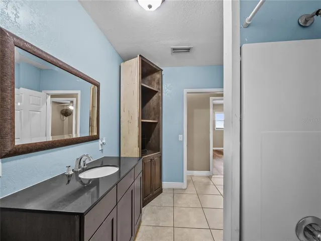 a bathroom with a granite countertop sink and a mirror