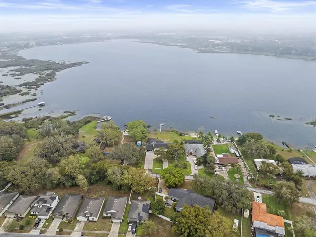 an aerial view of ocean and residential houses with outdoor space