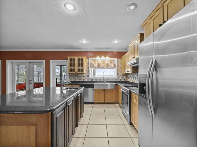 a kitchen with stainless steel appliances granite countertop a sink and a refrigerator