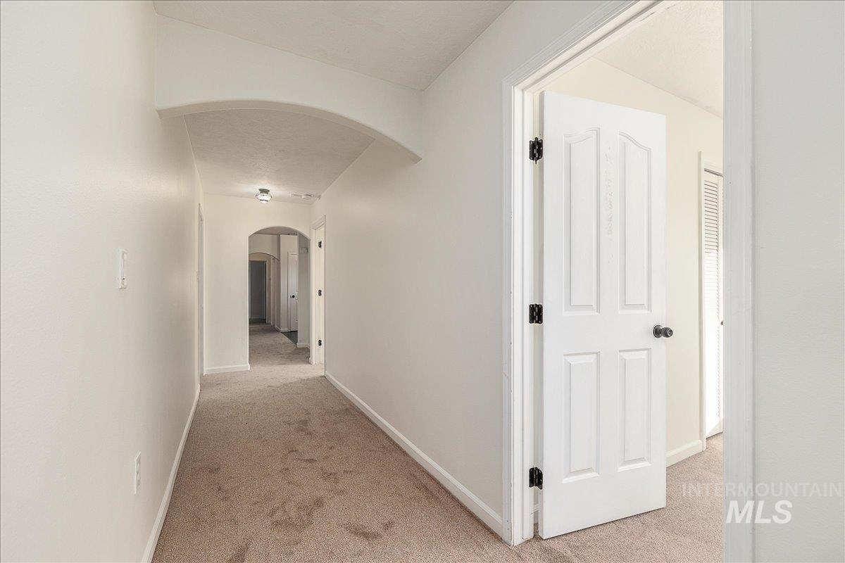 411 Hawthorne Street Nampa, ID 83686 - Photo 22 of 48 Corridor featuring light colored carpet and arched walkways