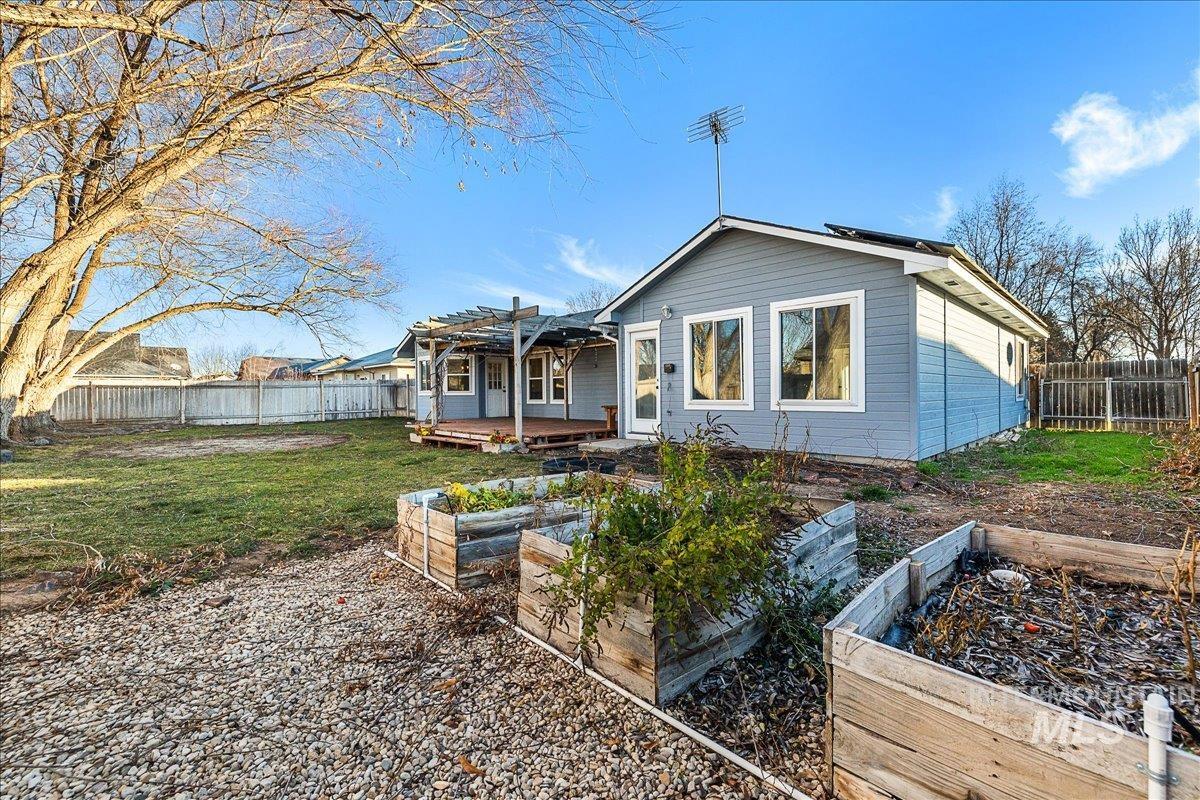 411 Hawthorne Street Nampa, ID 83686 - Photo 36 of 48 Rear view of house featuring a fenced backyard, a vegetable garden, a deck, and a pergola