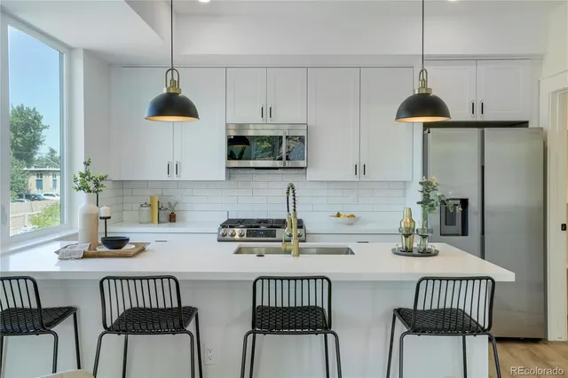 a kitchen with stainless steel appliances a kitchen island a stove a table and chairs
