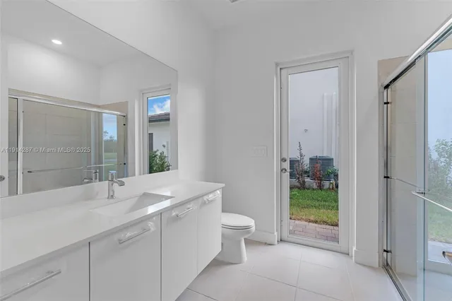 a spacious bathroom with a double vanity sink toilet and a mirror