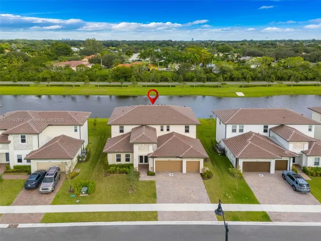 an aerial view of residential houses with outdoor space and ocean view
