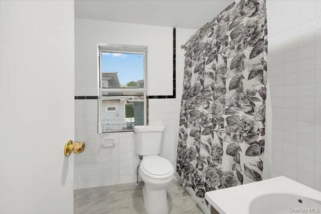 a bathroom with a toilet and a shower curtain