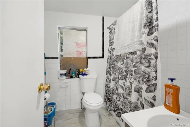 a bathroom with a toilet and a shower curtain