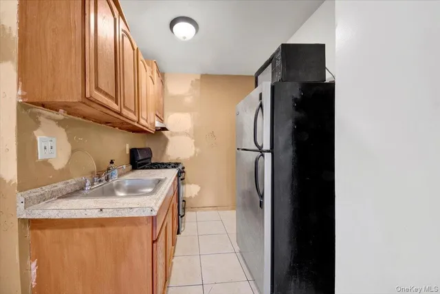 a kitchen with a sink a refrigerator and cabinets