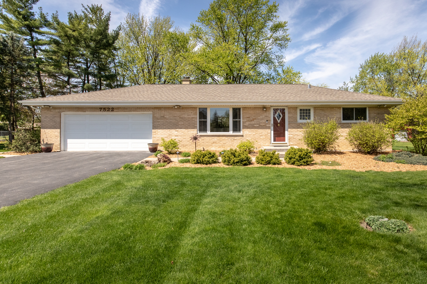 a front view of house with yard and green space