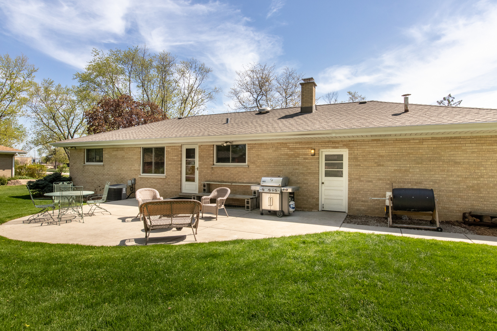 7522 Brookbank Road Willowbrook, IL 60527 - Photo 6 of 18 a view of a patio with table and chairs potted plants and a large tree