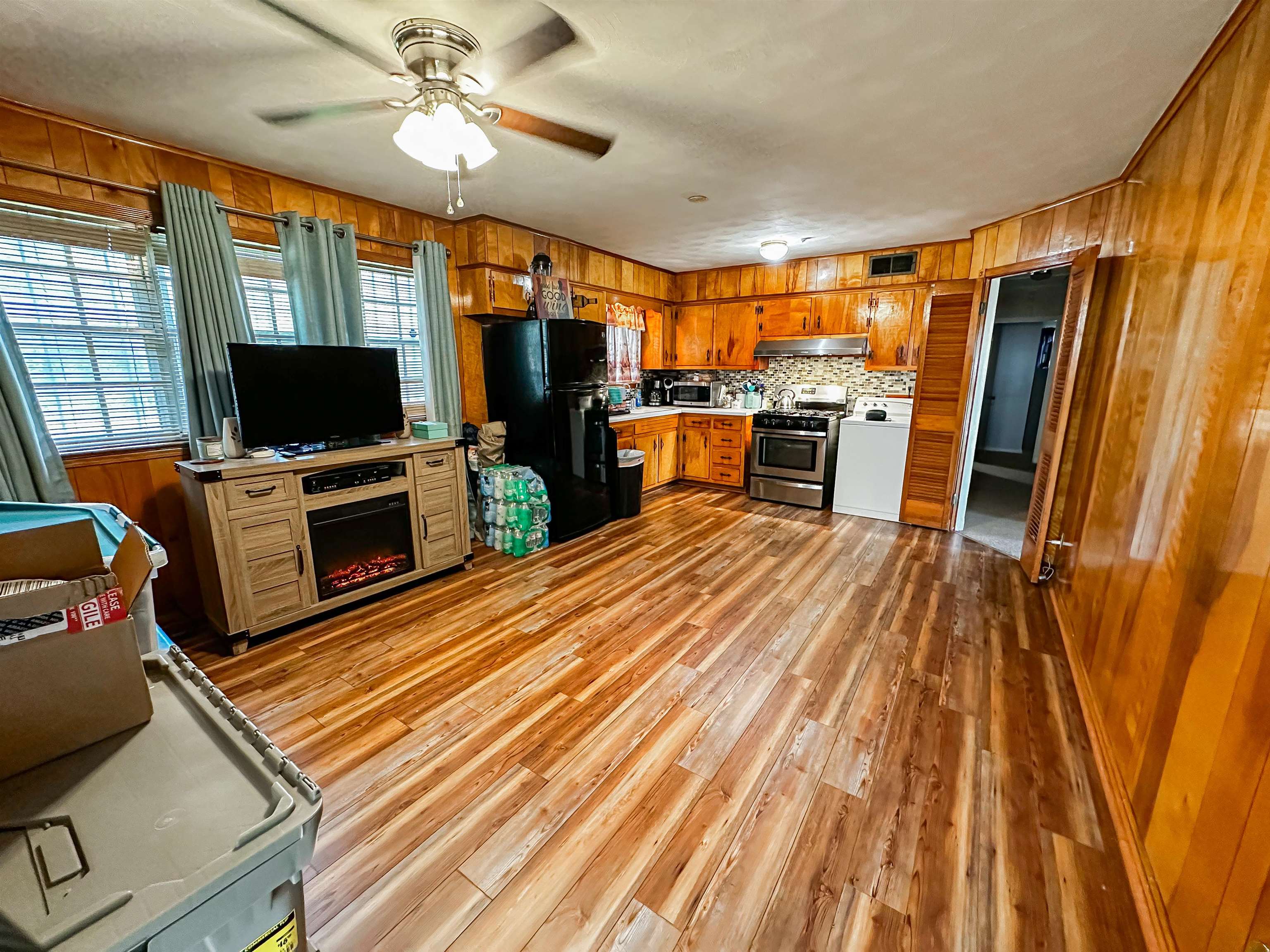 697 Shell Ln Avenue Memphis, TN 38109 - Photo 2 of 20 Kitchen with hardwood / wood-style flooring, stainless steel appliances, washer / clothes dryer, decorative backsplash, and ceiling fan. Room for sitting area or dining