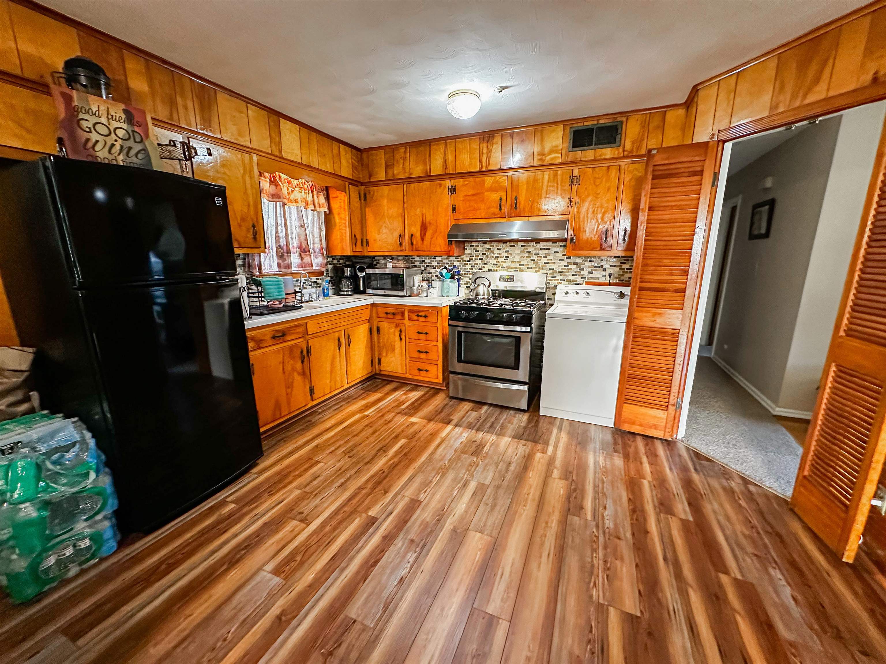 697 Shell Ln Avenue Memphis, TN 38109 - Photo 5 of 20 Kitchen featuring washer / clothes dryer, tasteful backsplash, stainless steel appliances, and carpet flooring