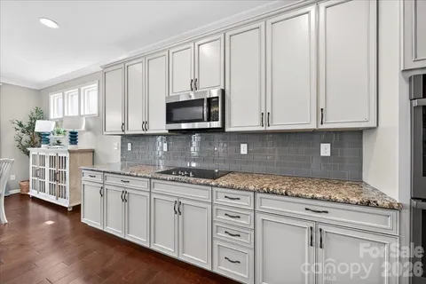 a large kitchen with stainless steel appliances granite countertop a lot of counter space and wooden cabinets