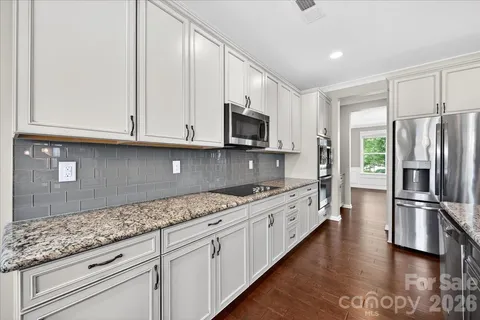 a kitchen with counter top space and wooden floor