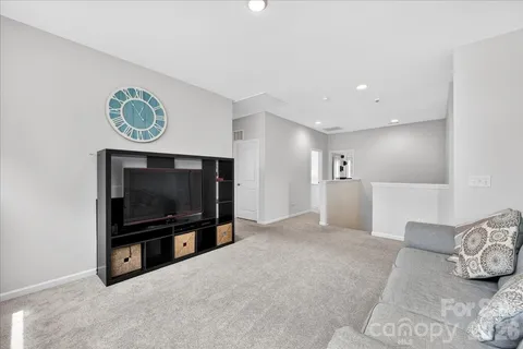 a bedroom with a large bed a chandelier and dresser