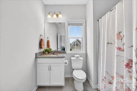 a bathroom with a granite countertop sink a mirror a vanity and a shower