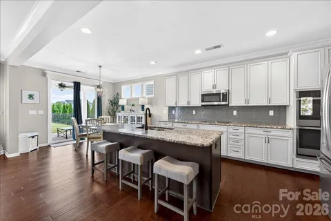 a kitchen with stainless steel appliances granite countertop a stove a sink and a microwave