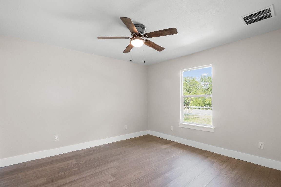 713 Burkett Street Taylor, TX 76574 - Photo 12 of 25 an empty room with wooden floor and windows