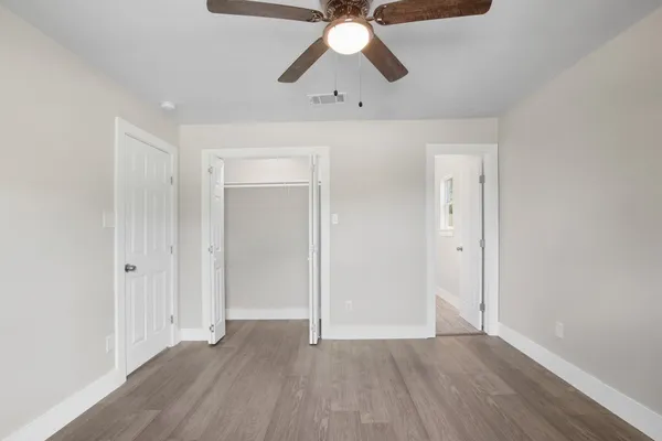 a view of empty room with wooden floor