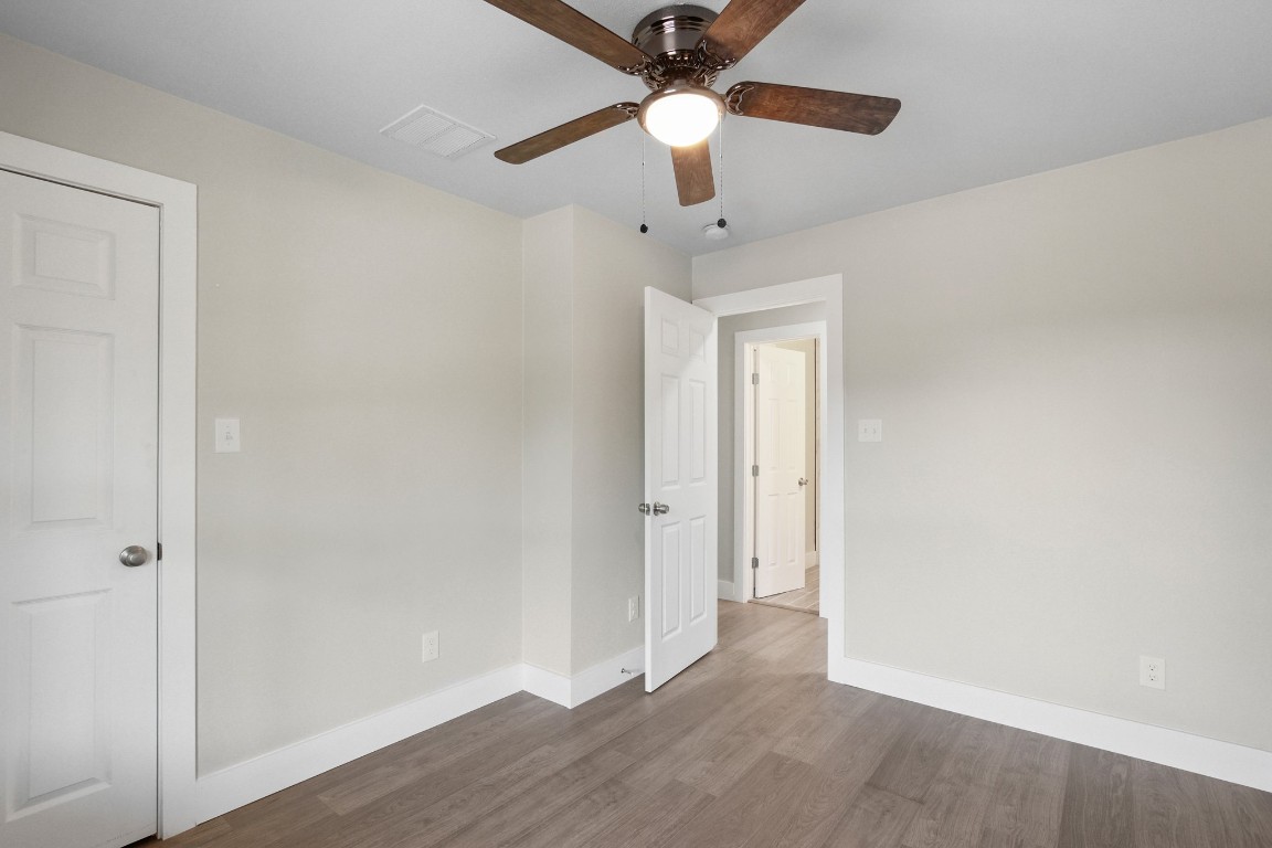 713 Burkett Street Taylor, TX 76574 - Photo 16 of 25 an empty room with wooden floor fan and windows