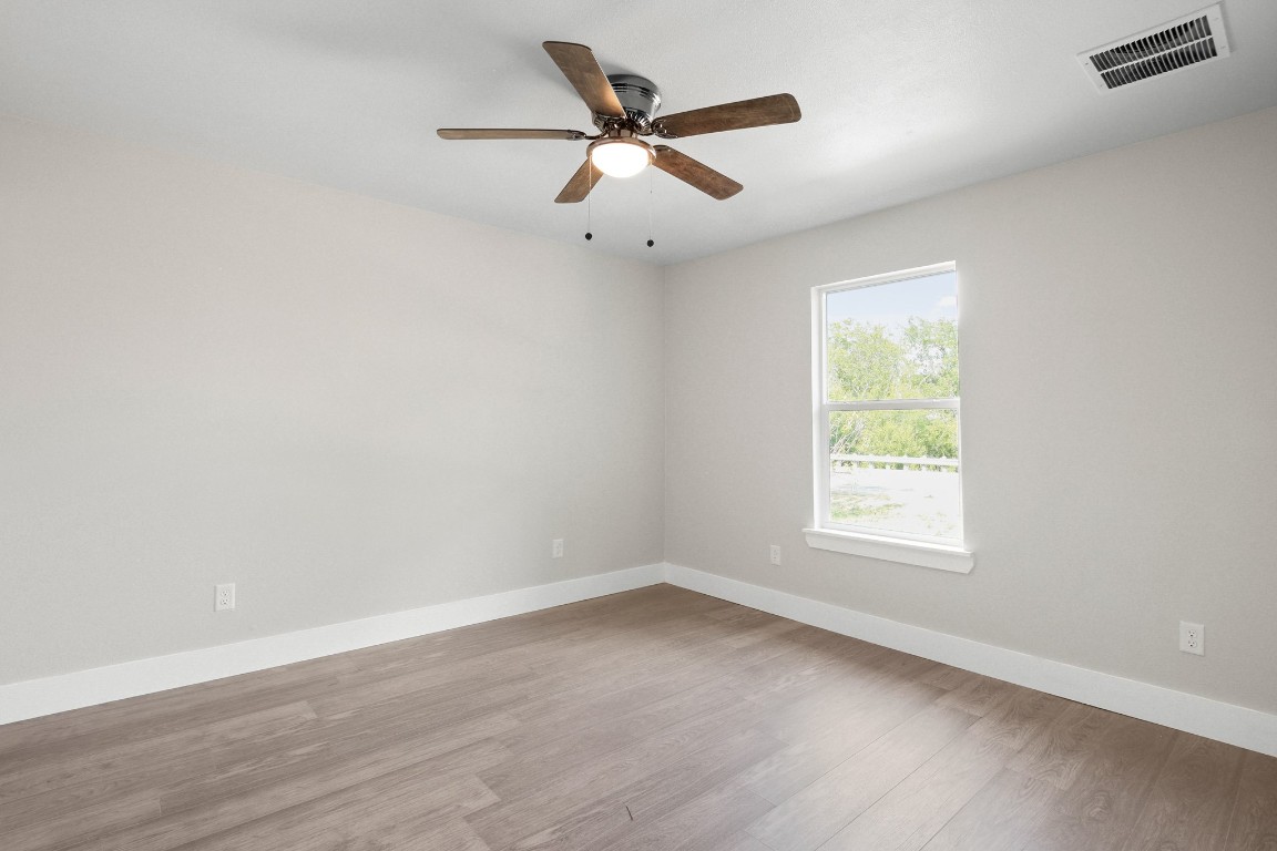 713 Burkett Street Taylor, TX 76574 - Photo 22 of 25 an empty room with wooden floor and windows