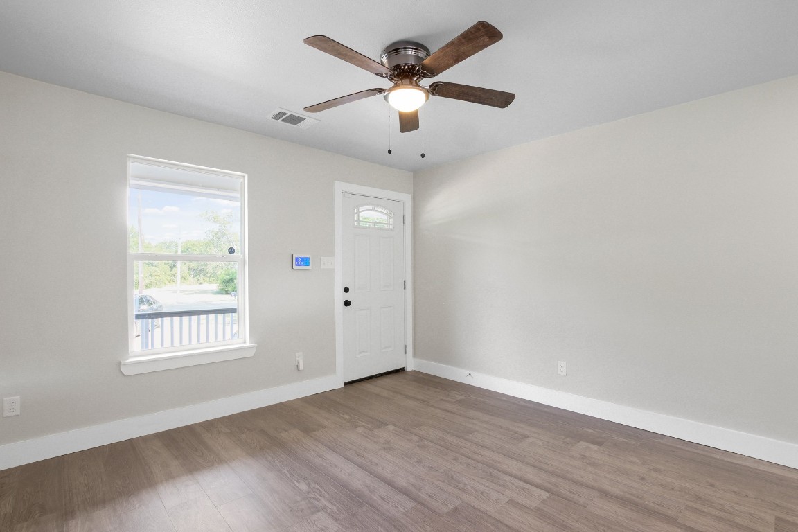 713 Burkett Street Taylor, TX 76574 - Photo 23 of 25 an empty room with wooden floor ceiling fan and windows