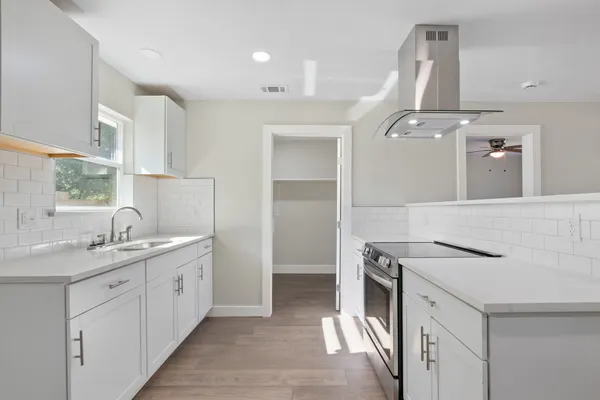 a kitchen with a sink stove and cabinets