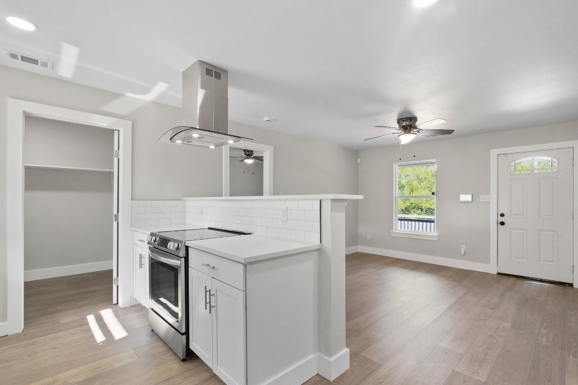 713 Burkett Street Taylor, TX 76574 - Photo 8 of 25 an empty room with wooden floor cabinet and windows