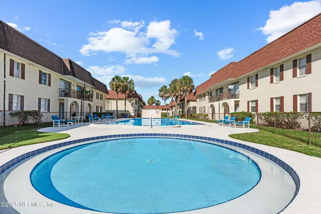 a view of a house with swimming pool and sitting area
