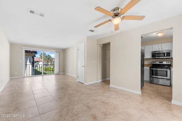 a view of an empty room with a kitchen