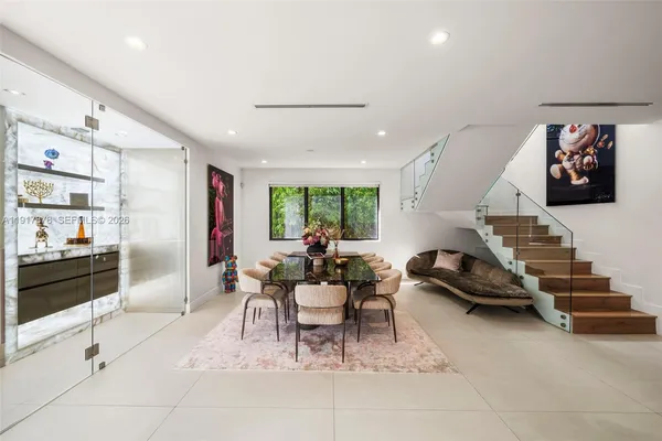 a view of a dining room with furniture one side kitchen view and wooden floor