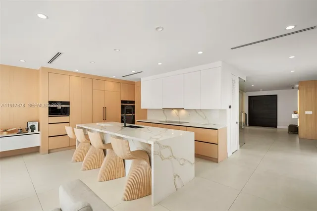 a kitchen with stainless steel appliances a table and chairs in it