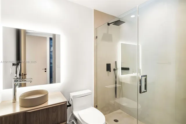 a bathroom with a granite countertop sink mirror and shower