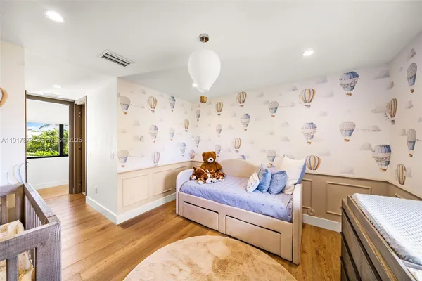a bedroom with a bed and a flat tv screen next to a window