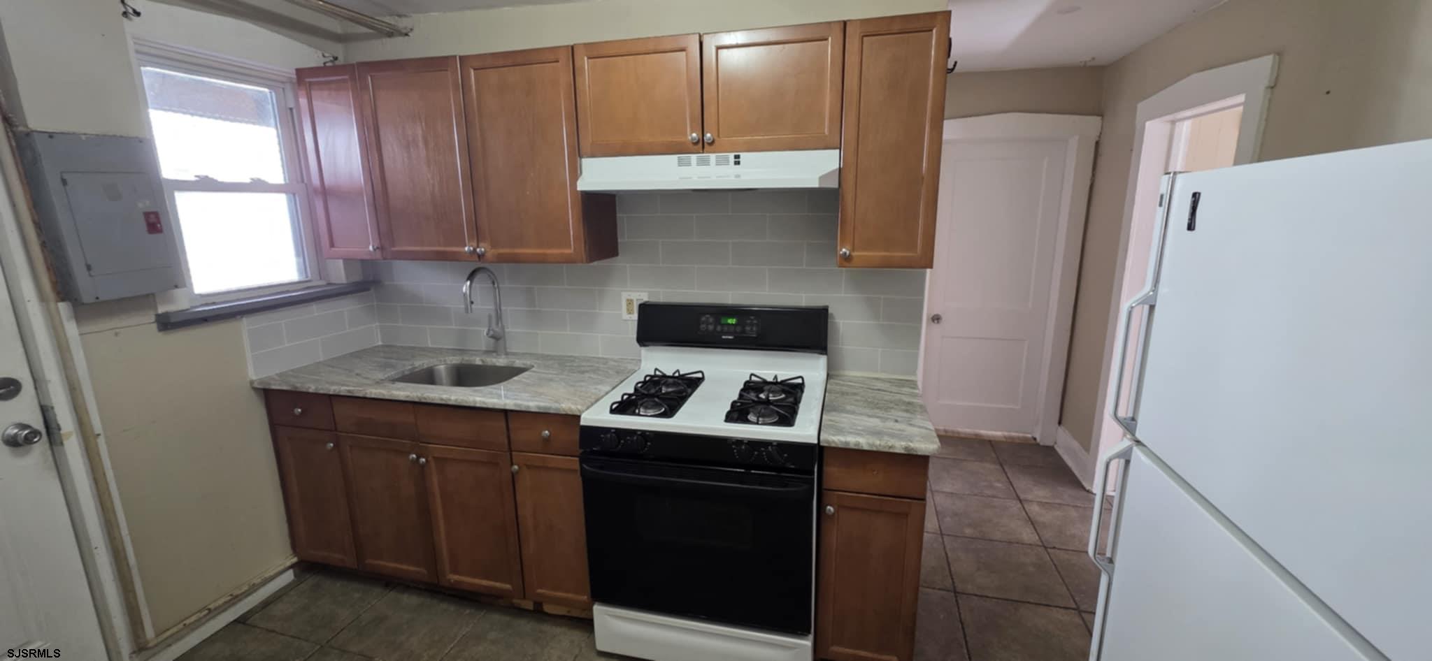 1419 Drexel Avenue, Unit 2 Atlantic City, NJ 08401 - Photo 2 of 9 a kitchen with a sink stove and refrigerator