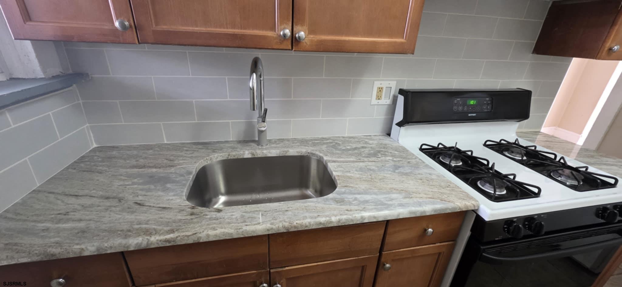 1419 Drexel Avenue, Unit 2 Atlantic City, NJ 08401 - Photo 3 of 9 a kitchen with a sink stainless steel appliances and cabinets