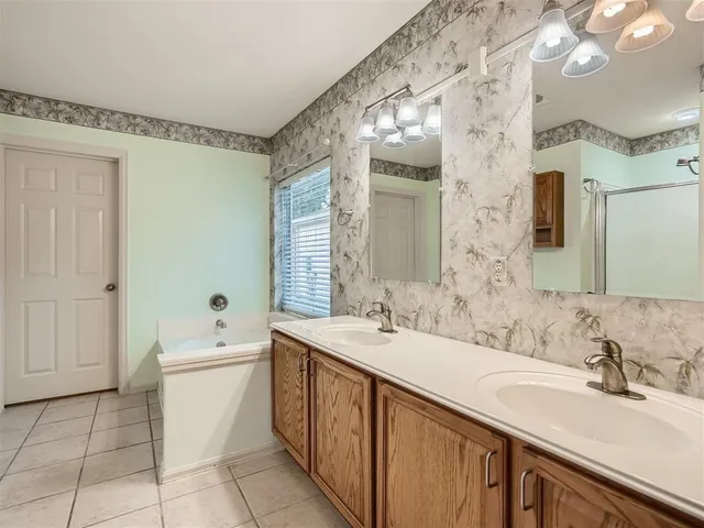 a bathroom with a sink a large mirror and a bathtub