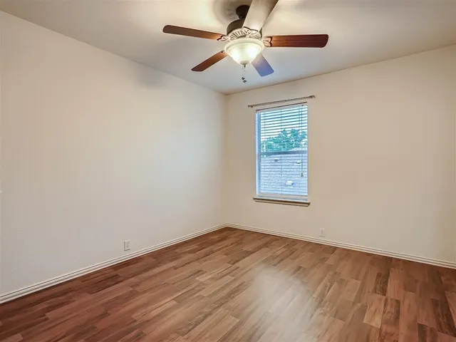 an empty room with a window and a ceiling fan