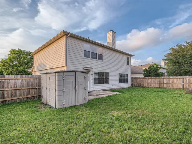a view of a house with backyard and wooden fence