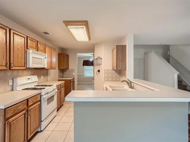 a kitchen with a sink stove and cabinets