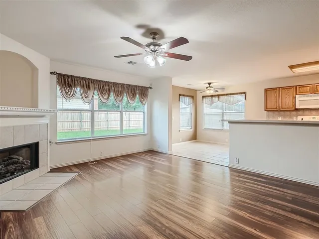 a view of an empty room with a window and fireplace