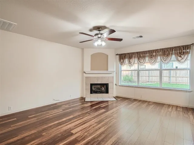a view of an empty room with a fireplace and a window
