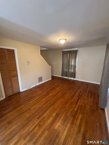 a view of an empty room with wooden floor