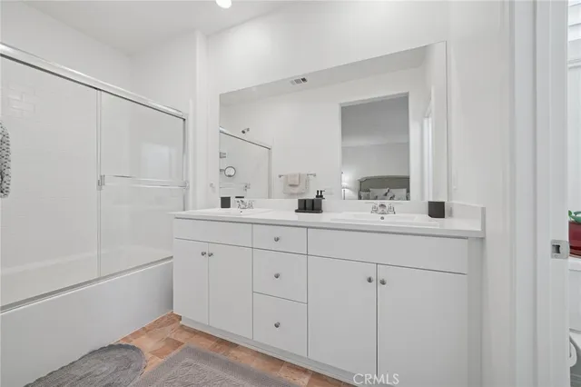 a bathroom with double vanity sink a mirror and a shower