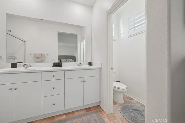 a bathroom with a sink a toilet and a mirror
