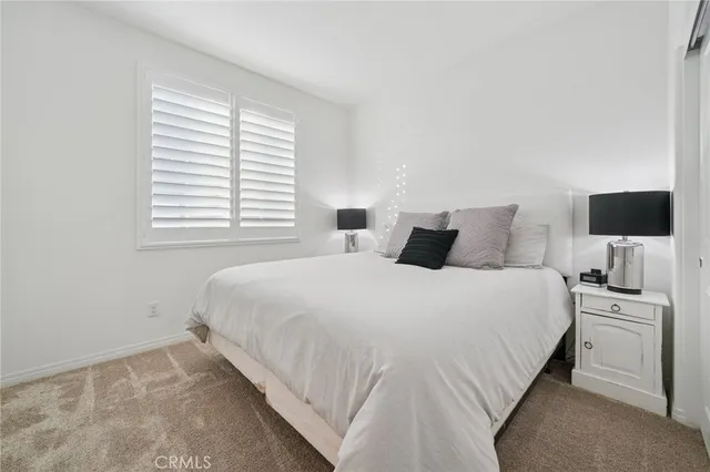 a bedroom with a bed tv and a window