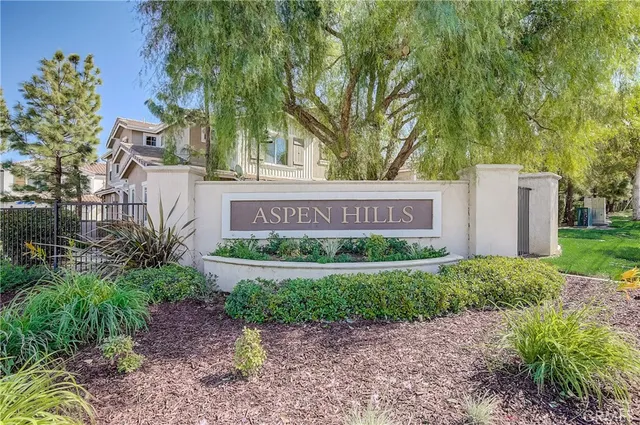 a sign that is sitting in front of a brick house