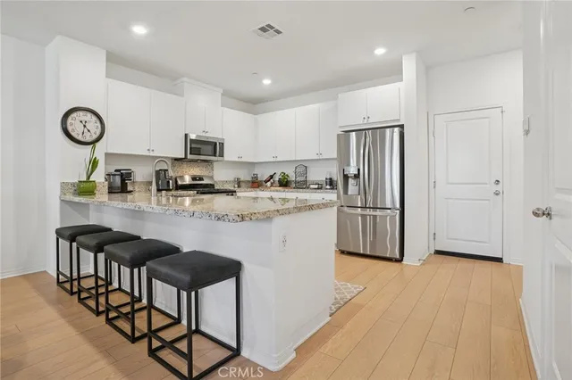a kitchen with stainless steel appliances granite countertop a refrigerator a stove top oven a sink and dishwasher
