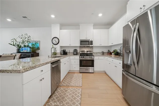 a kitchen with stainless steel appliances granite countertop a refrigerator sink and cabinets