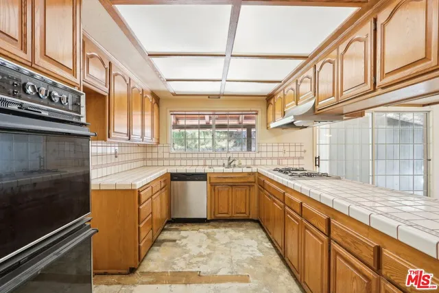 a kitchen with stainless steel appliances granite countertop a sink and cabinets