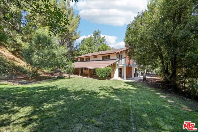 a view of a house with a yard and tree s